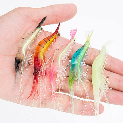 Assorted soft plastic shrimp lures in five colors shown in hand, designed for snook, redfish, and tarpon saltwater fishing